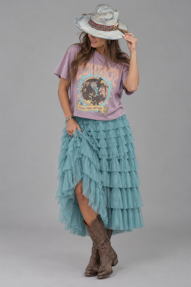 Trestles Clothing Company teal ruffled tulle maxi skirt paired with a graphic tee, cowboy hat, and brown boots